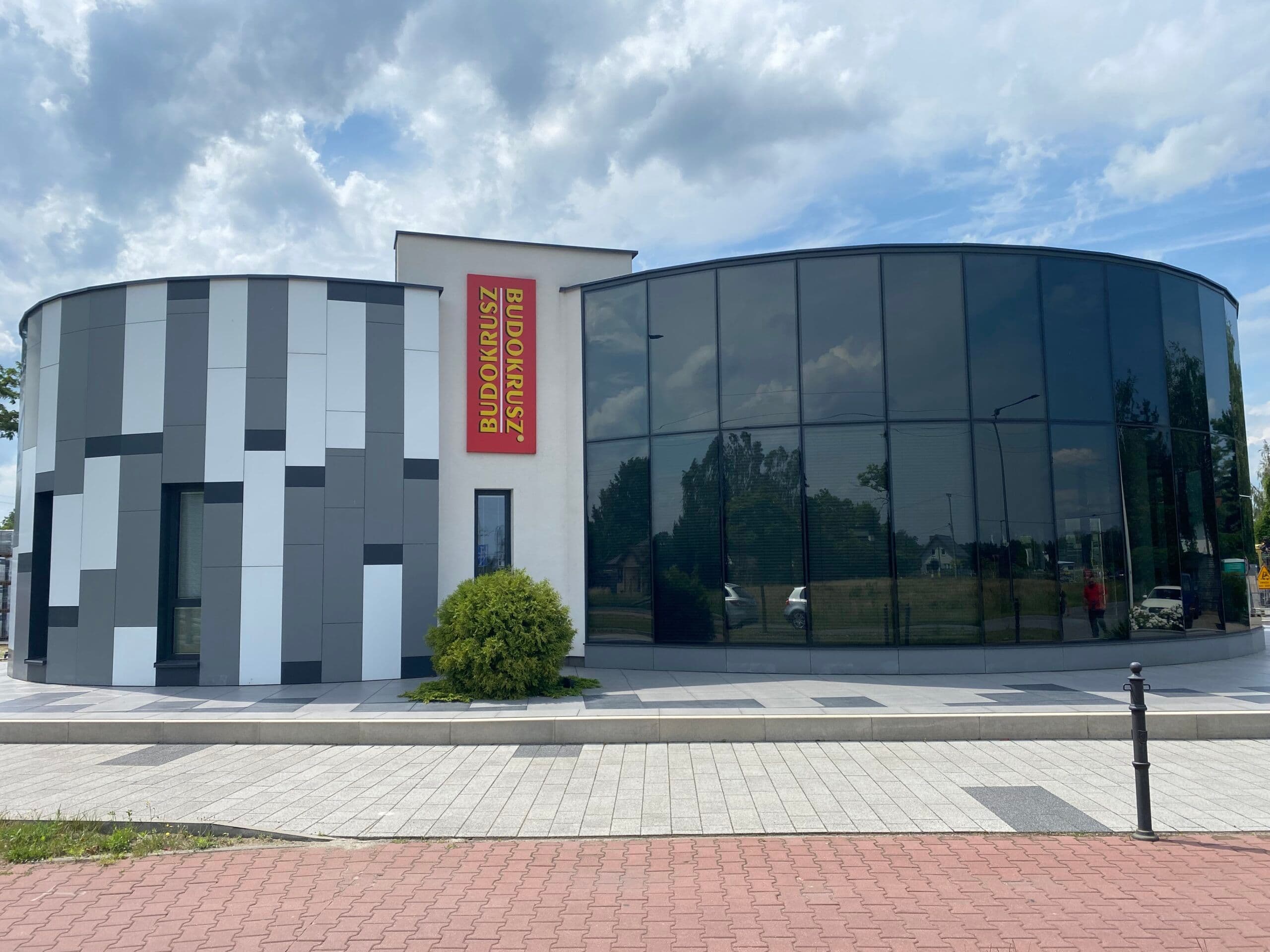 Fasada szklana oraz elewacja wielokolorowa z oknami, całość na konstrukcji aluminiowej w budynku na planie koła