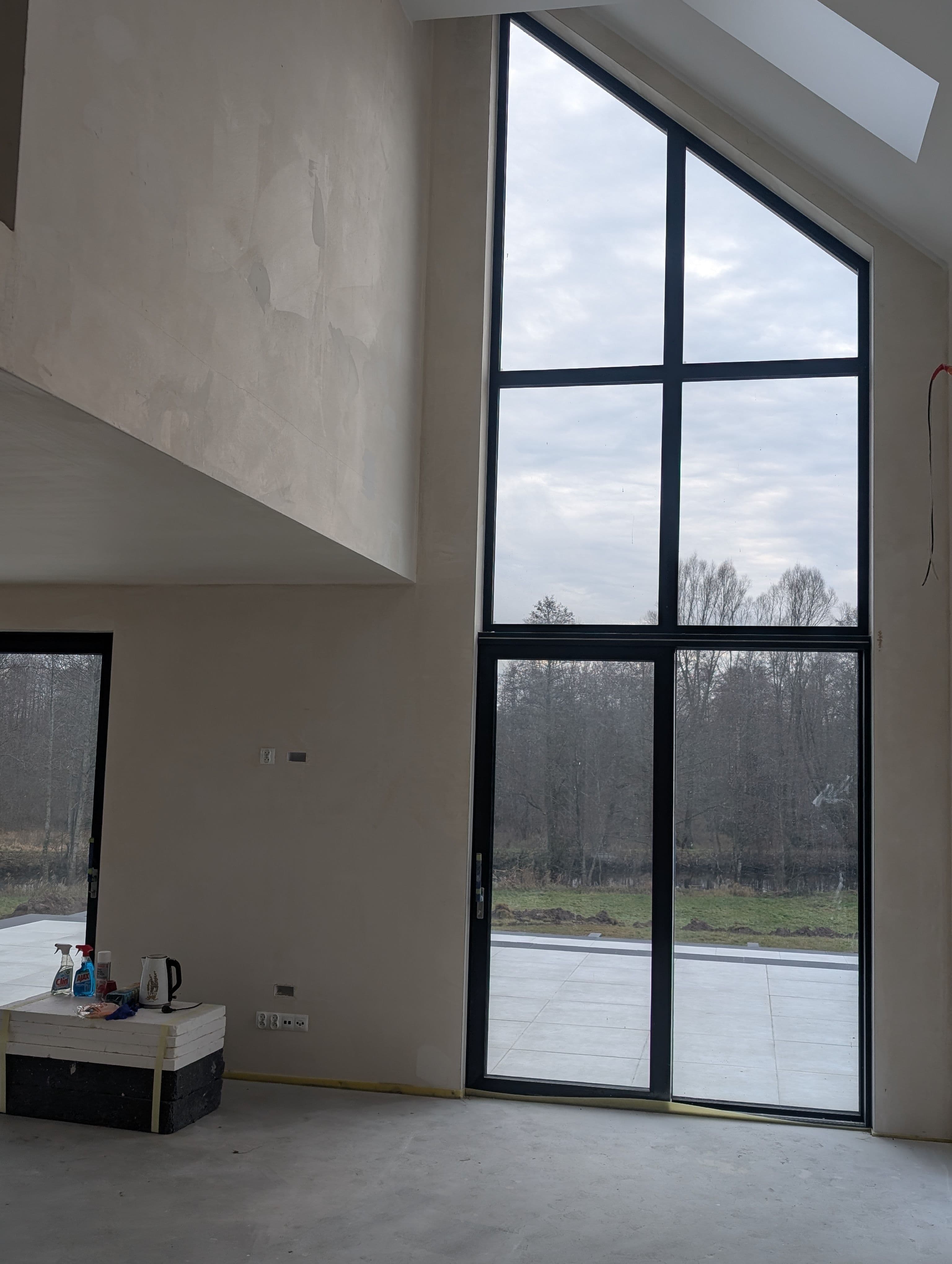 Aluminiowe: fasada dwukondygnacyjna, trójkątne okno panoramiczne oraz okno przesuwne typu HS w domu jednorodzinnym