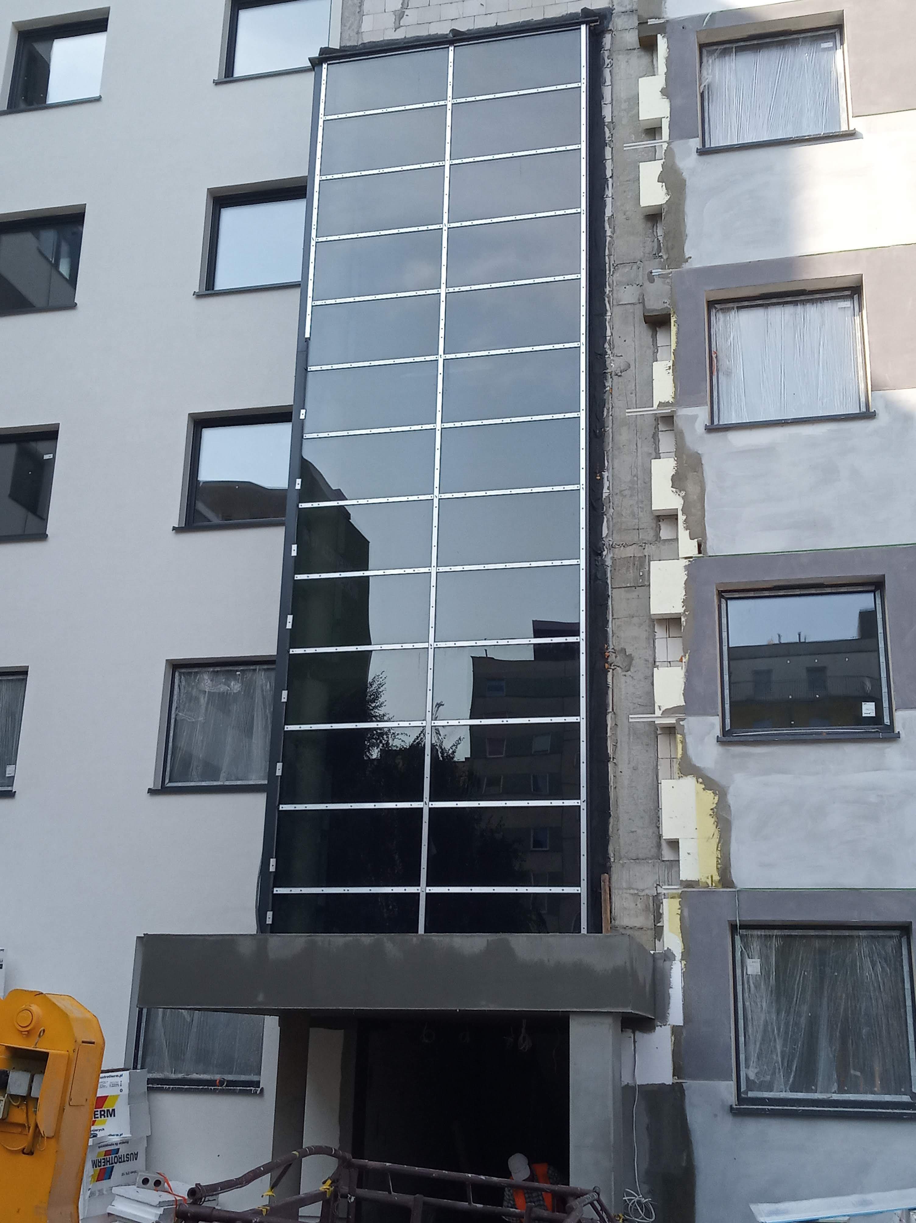 Fasada aluminiowa na 4 piętra oraz aluminiowe drzwi wejściowe.