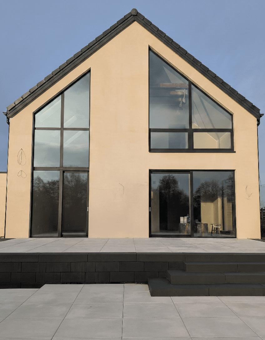 Aluminiowe: fasada dwukondygnacyjna, trójkątne okno panoramiczne oraz okno przesuwne typu HS w domu jednorodzinnym