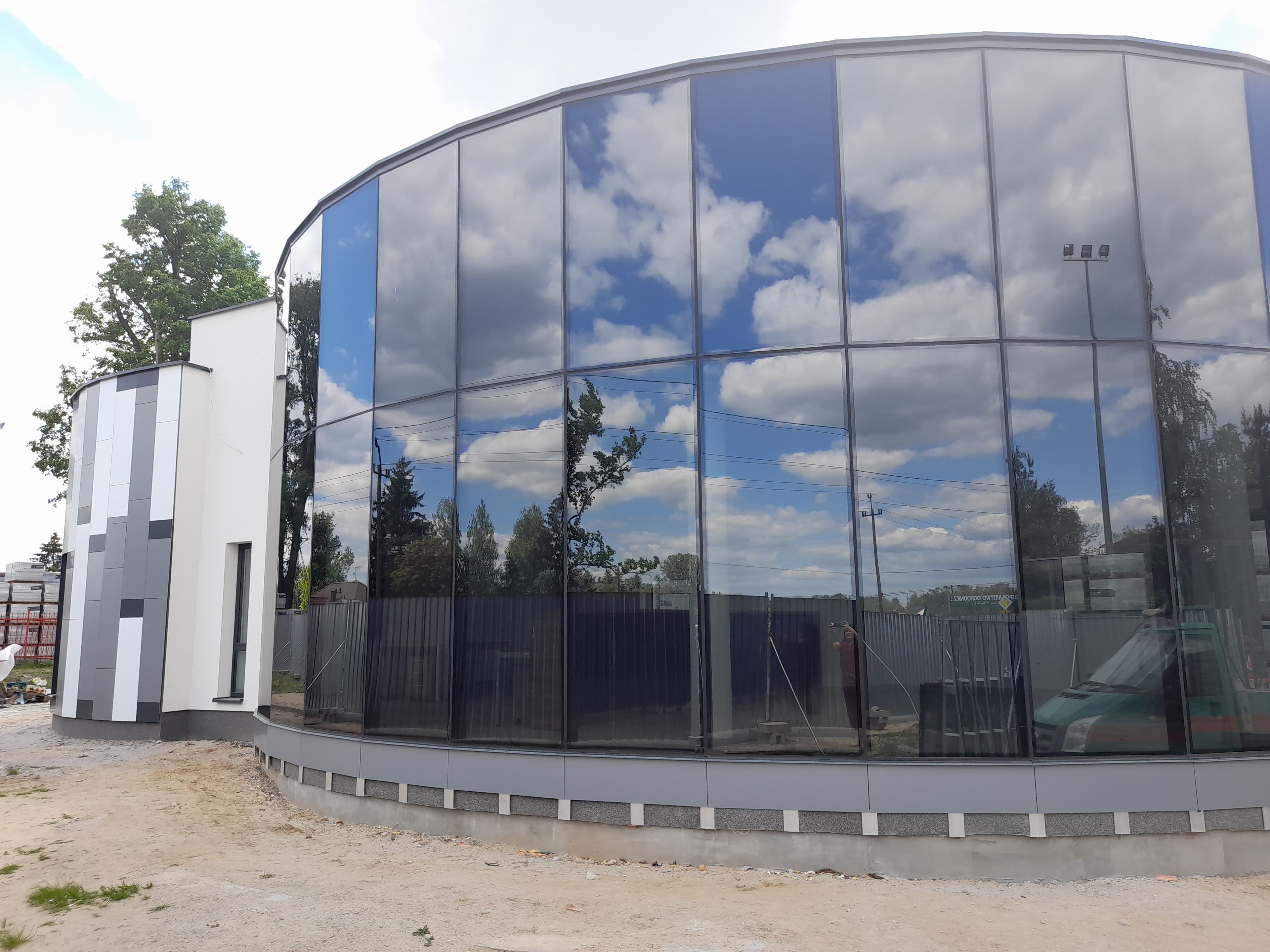 Fasada szklana oraz elewacja wielokolorowa z oknami, całość na konstrukcji aluminiowej w budynku na planie koła