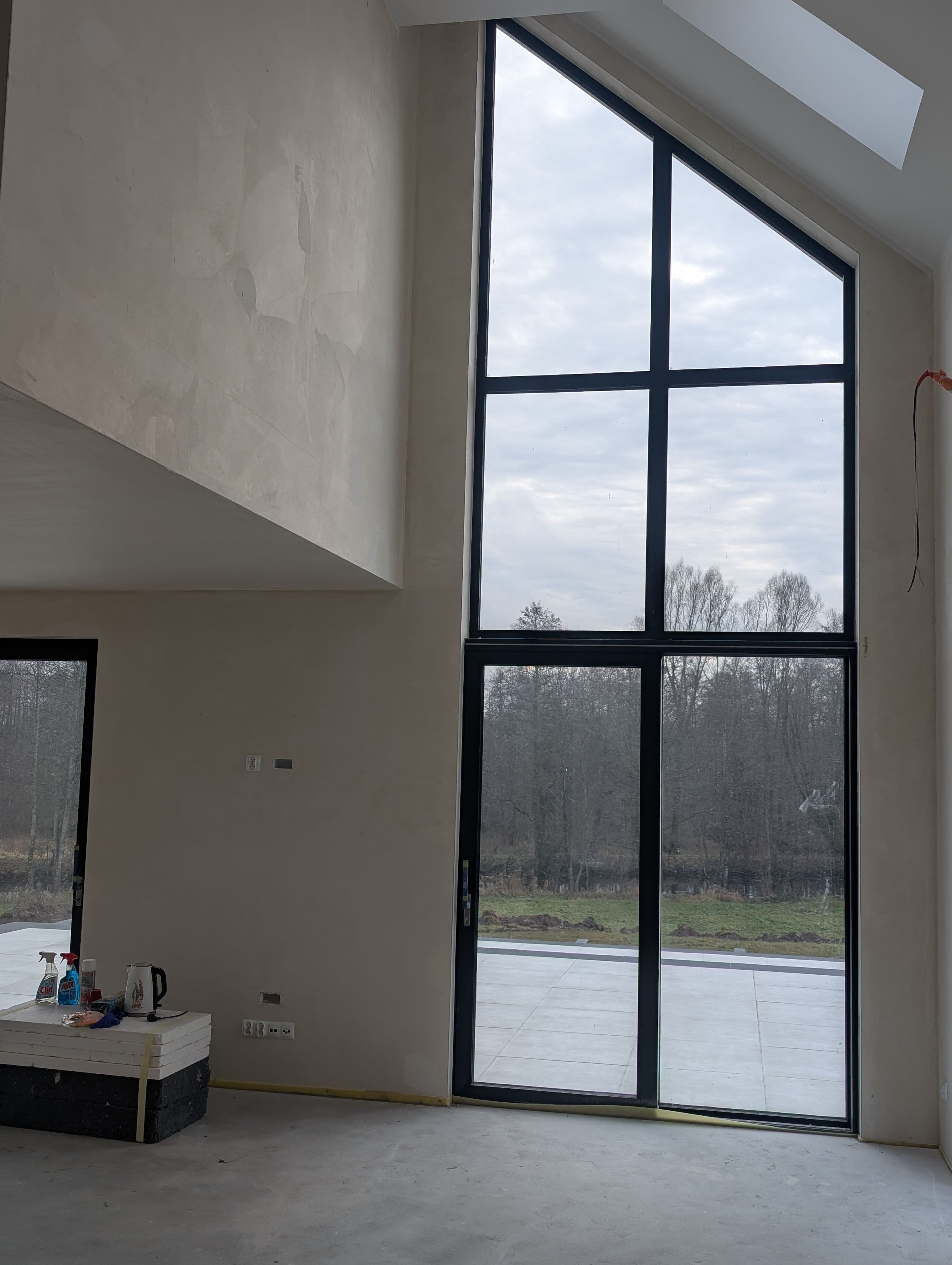 Aluminiowe: fasada dwukondygnacyjna, trójkątne okno panoramiczne oraz okno przesuwne typu HS w domu jednorodzinnym